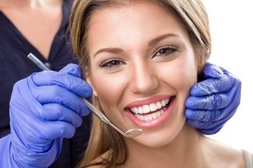 woman smiling with dental tool l gum disease mesquite tx
