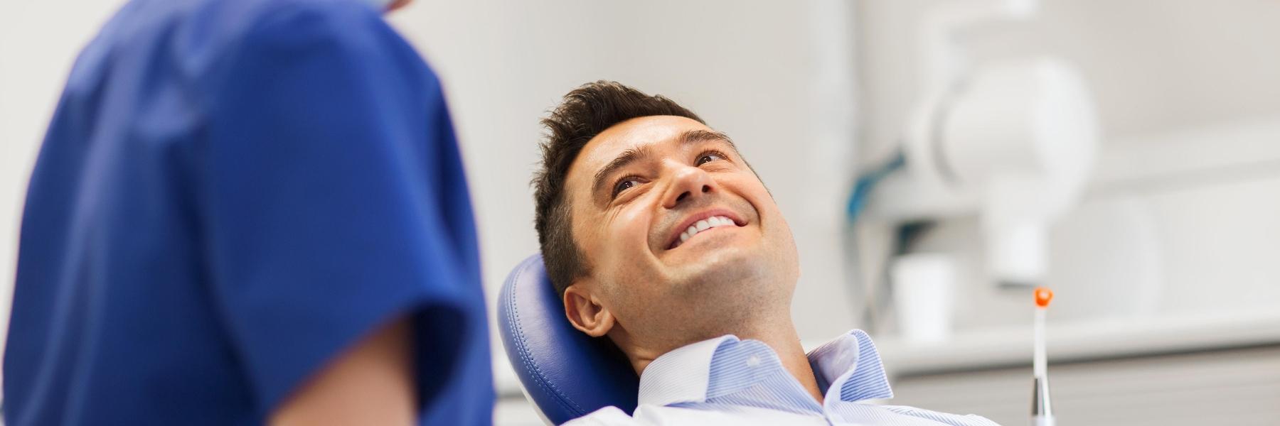 man laying down in dental exam chair smiling l dds mesquite tx