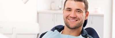 man sitting in dental exam chair | dentist in mesquite tx