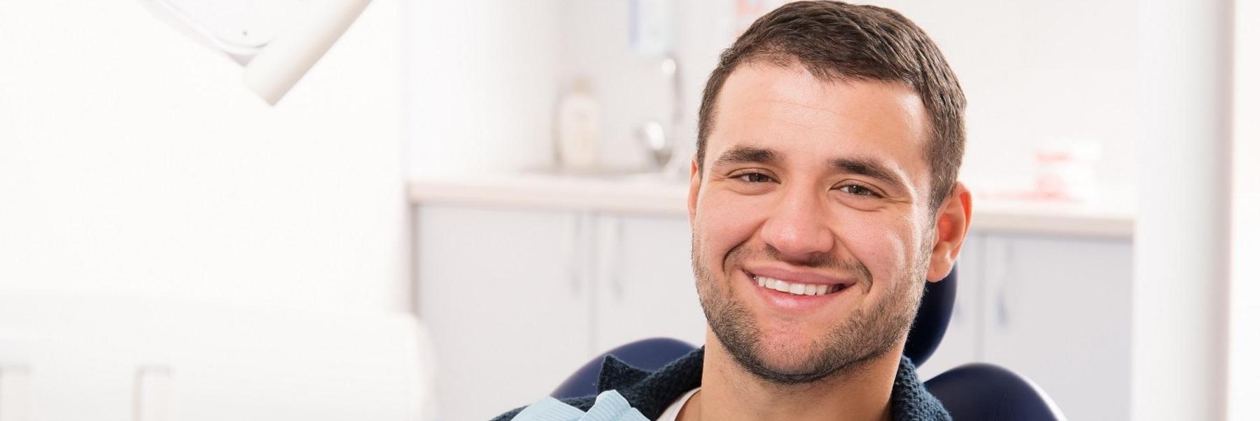 man smiling in dental exam chair l periodontal disease mesquite tx